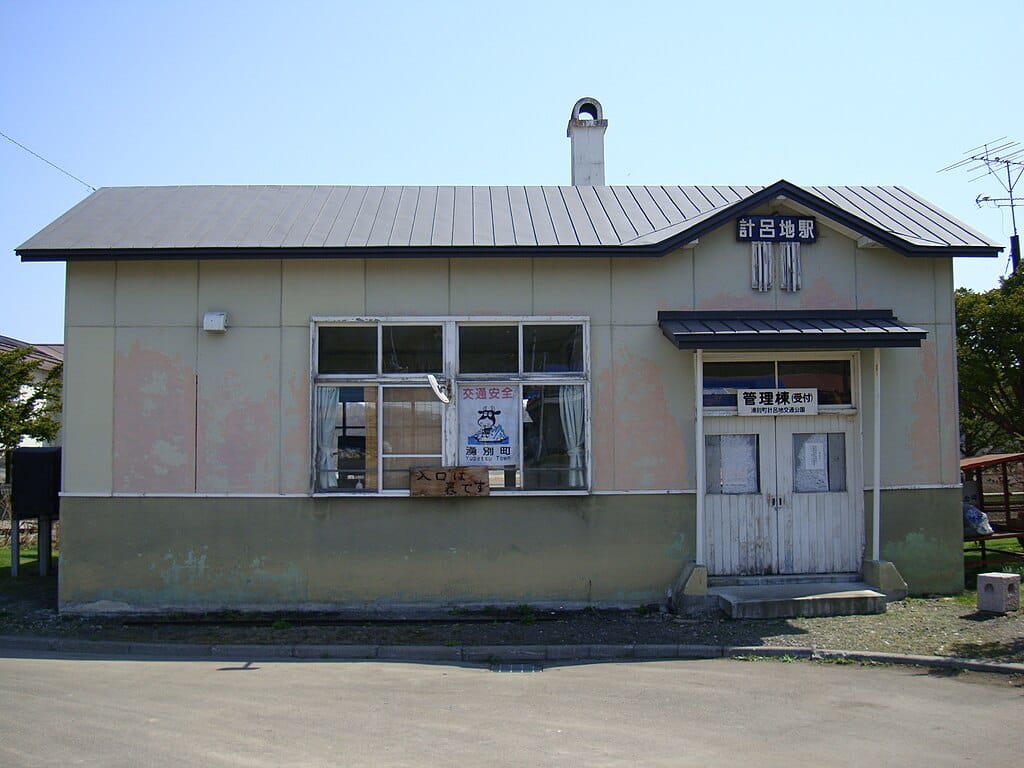 A photo of Kerochi Station, an abandoned train station in Hokkaido. A small building with a brown roof and white doors.